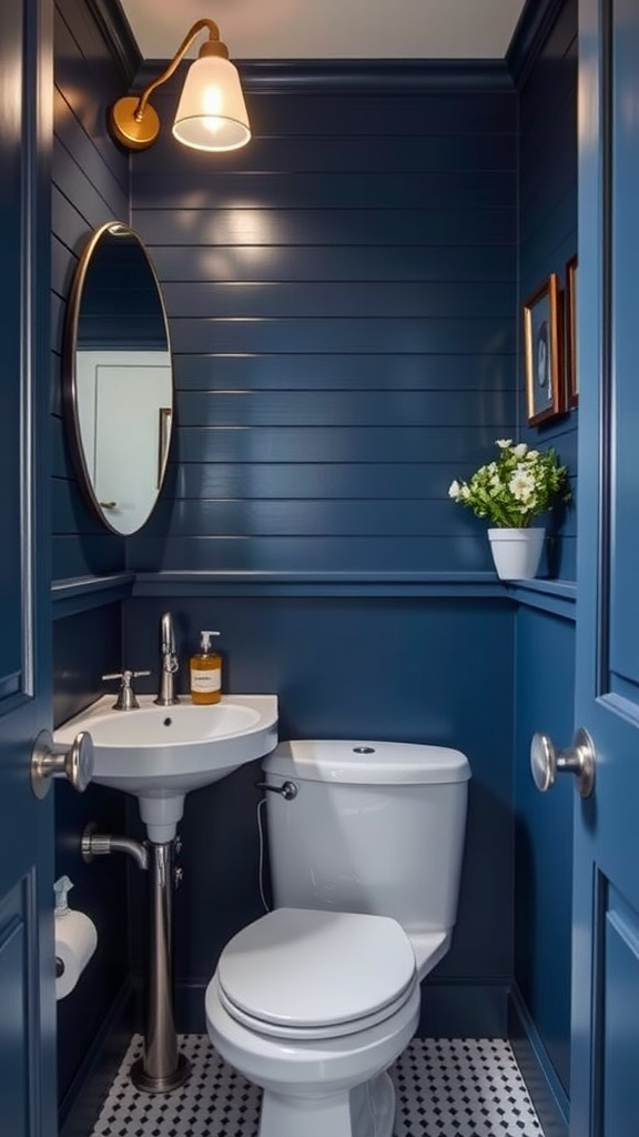 A small bathroom with navy blue walls, a round mirror, and a white sink and toilet.